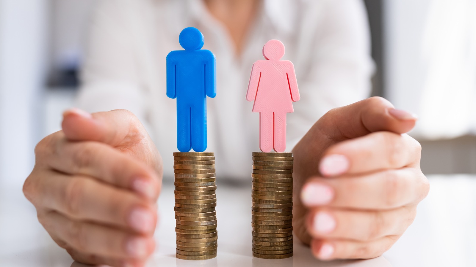 foto de una composición de dos columnas de monedas sobre las que hay unas figuras de hombre y mujer.